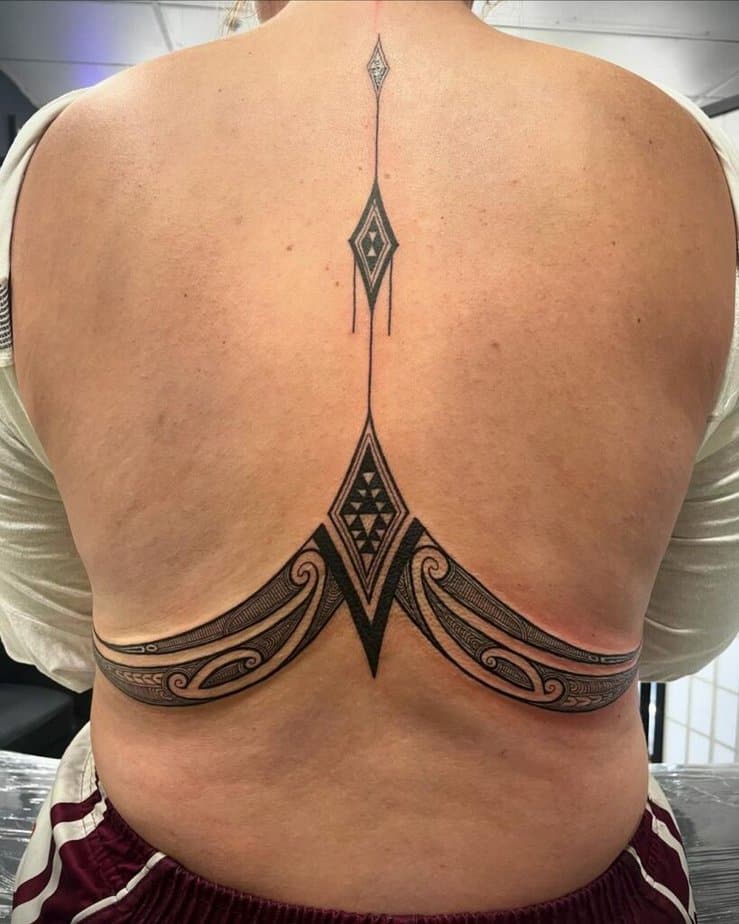 13. Beautifully symmetric lower back Maori tattoo