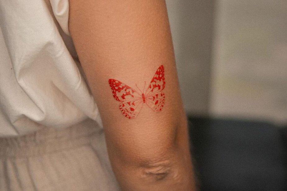 1. Un delicato tatuaggio a forma di farfalla rossa 