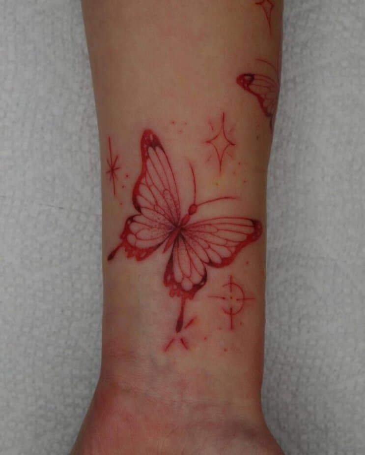 16. A red butterfly hand tattoo 