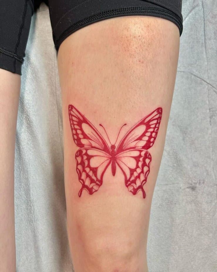 7. A red butterfly tattoo on the thigh