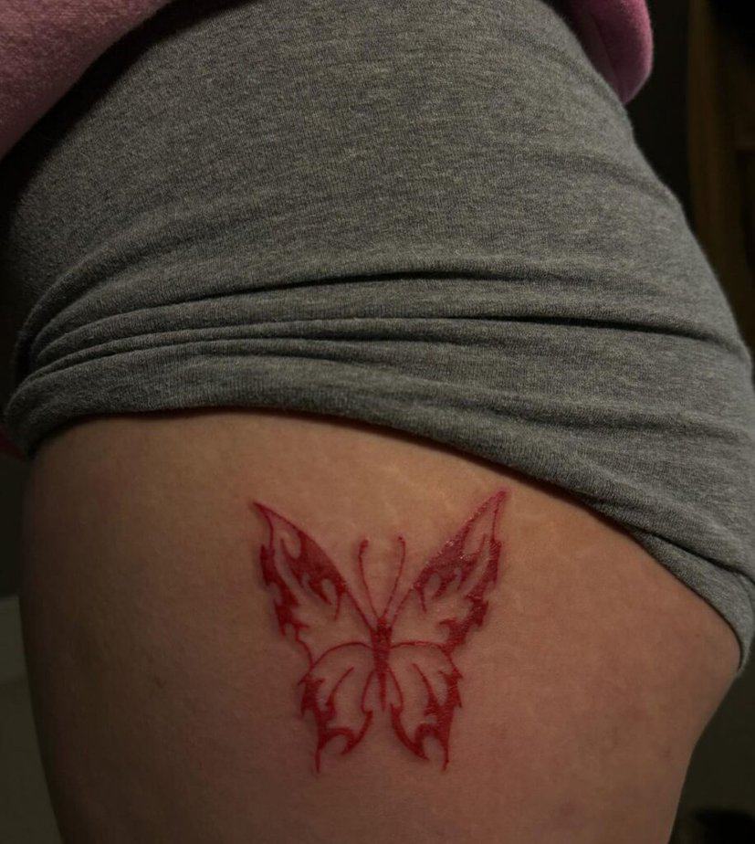 9. A red butterfly tattoo on the hip