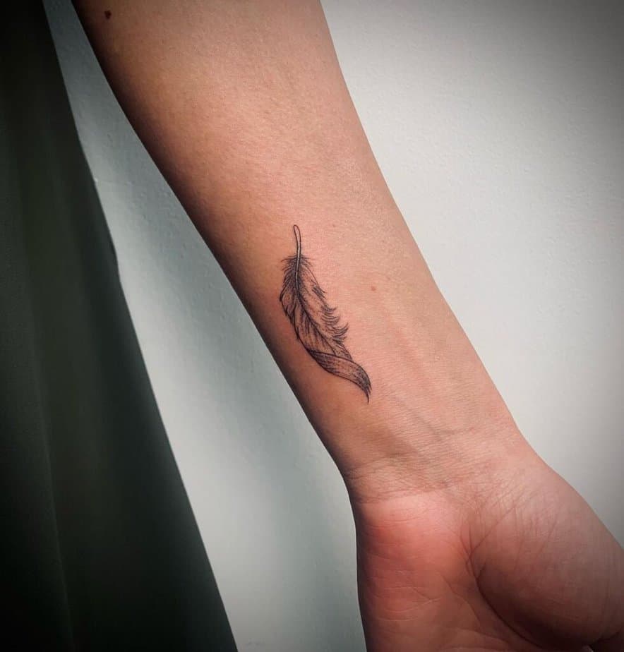 1. A fine-line feather tattoo