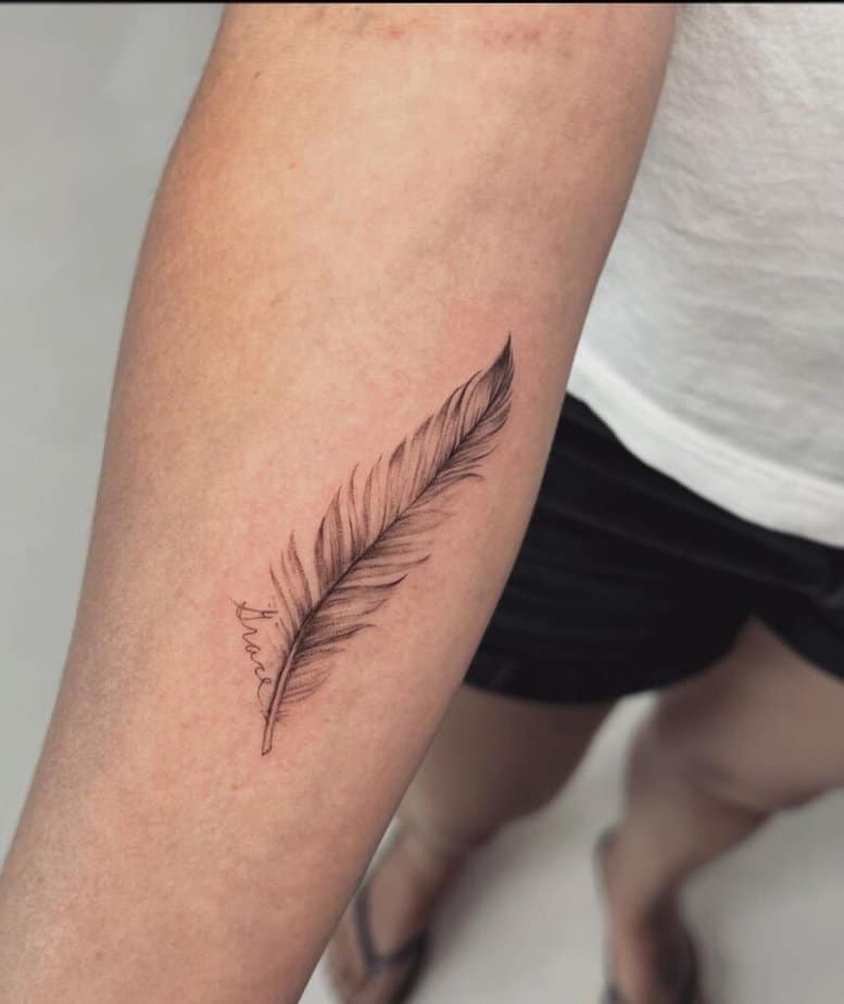 11. A feather tattoo with the name of someone special