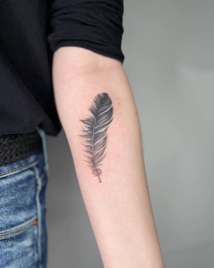 13. A simple and sleek feather tattoo on the forearm 