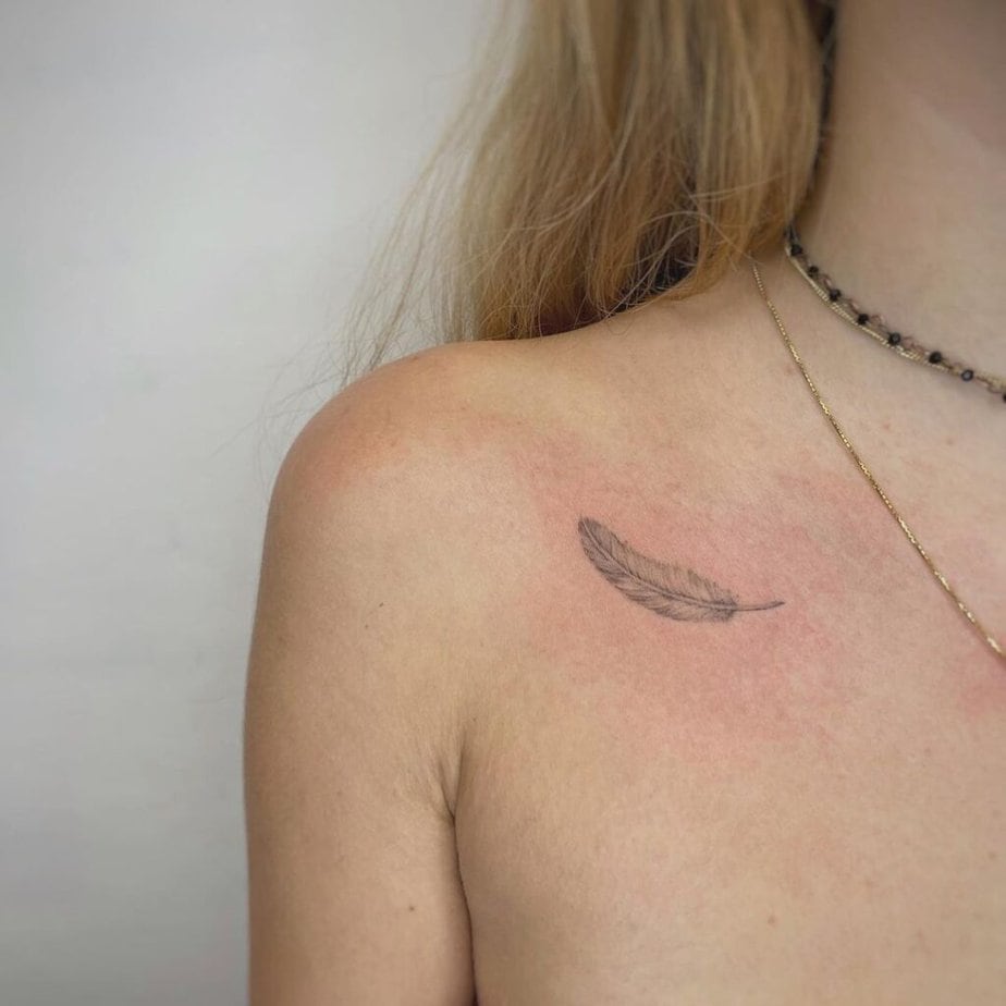 16. A dainty and delicate feather tattoo on the collarbone