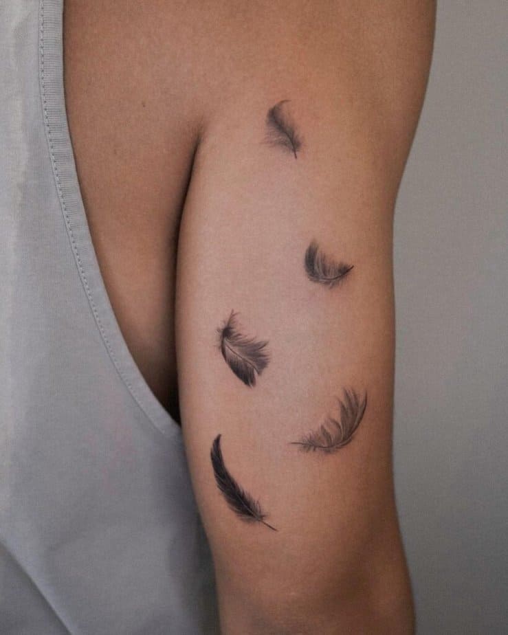 17. A tattoo of a couple of feathers on the back of the arm