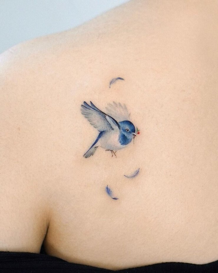 7. A tattoo of a bird with feathers flying around 