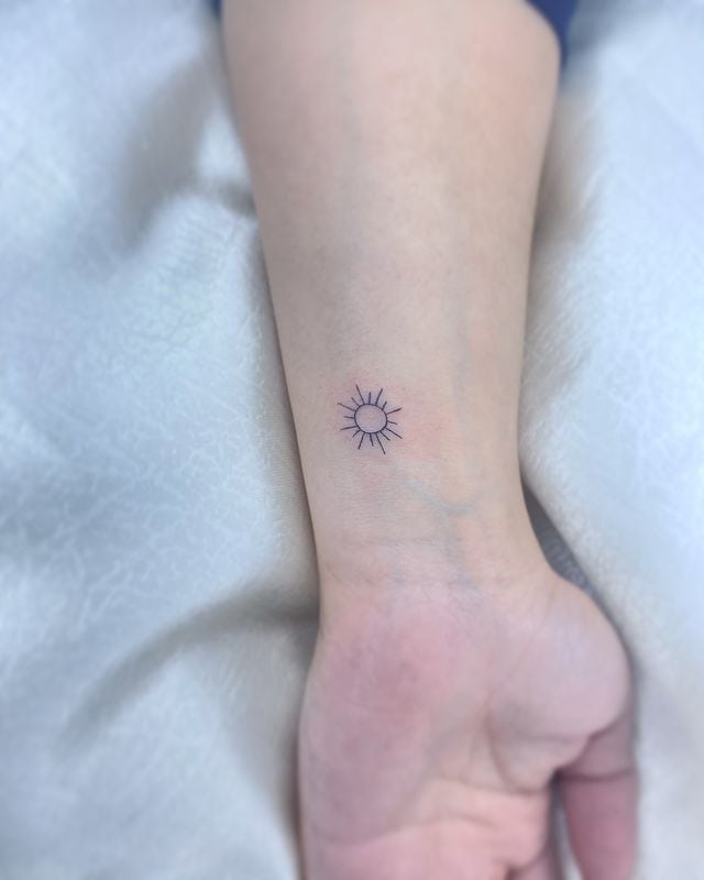 Tiny sun tattoo