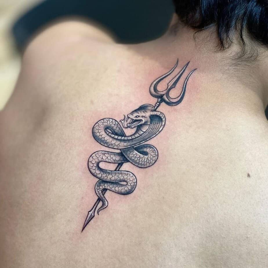 14. Tatuaggio di un tridente e di un serpente sulla schiena