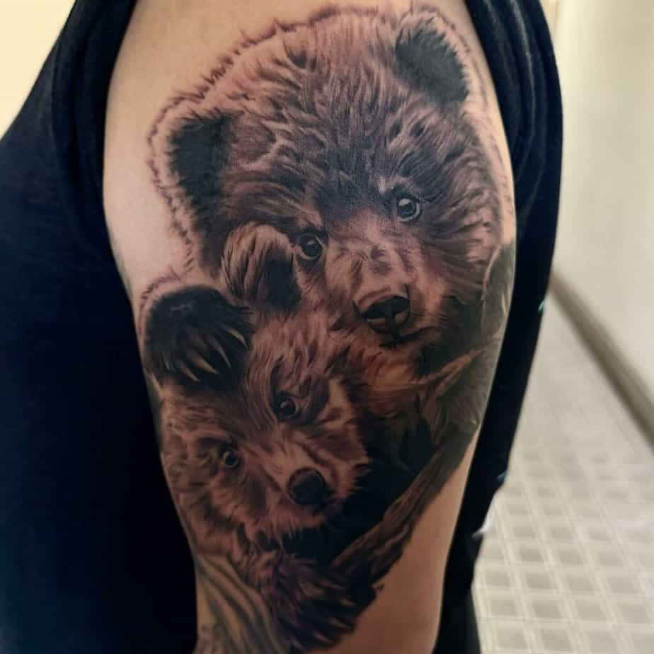 21. Un tatuaggio di due cuccioli sulla parte superiore del braccio
