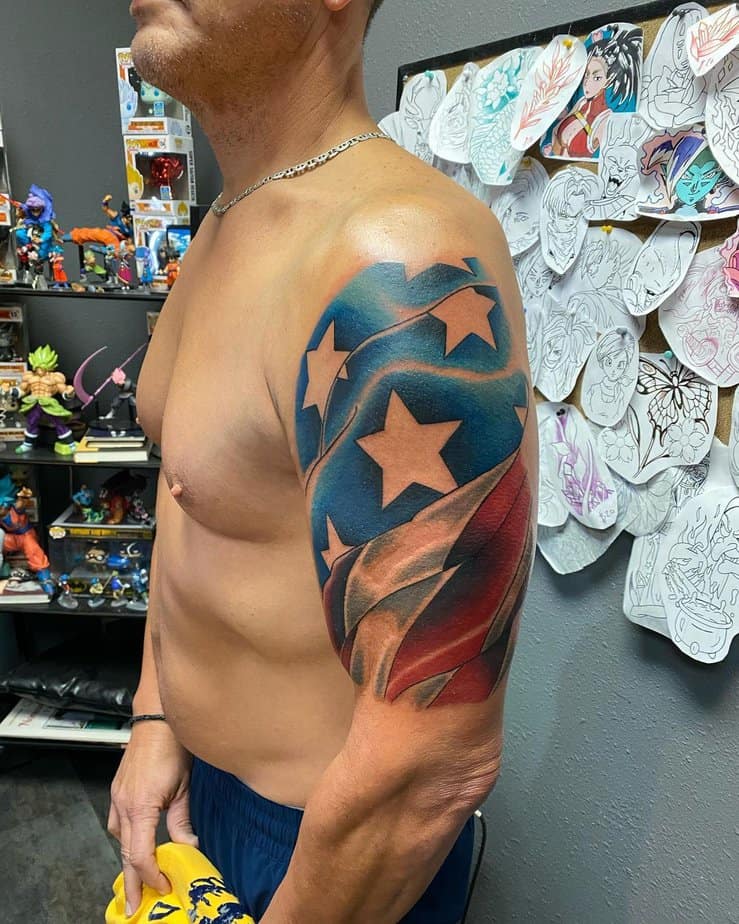 32. Colorful shoulder flag tattoo