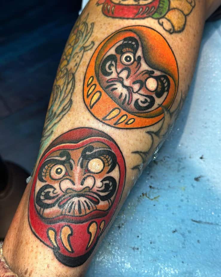 8. Red and orange daruma tattoos