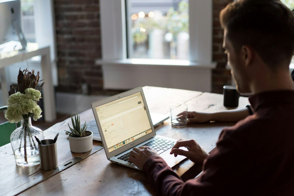 Man sitting at a desk and working on his laptop.