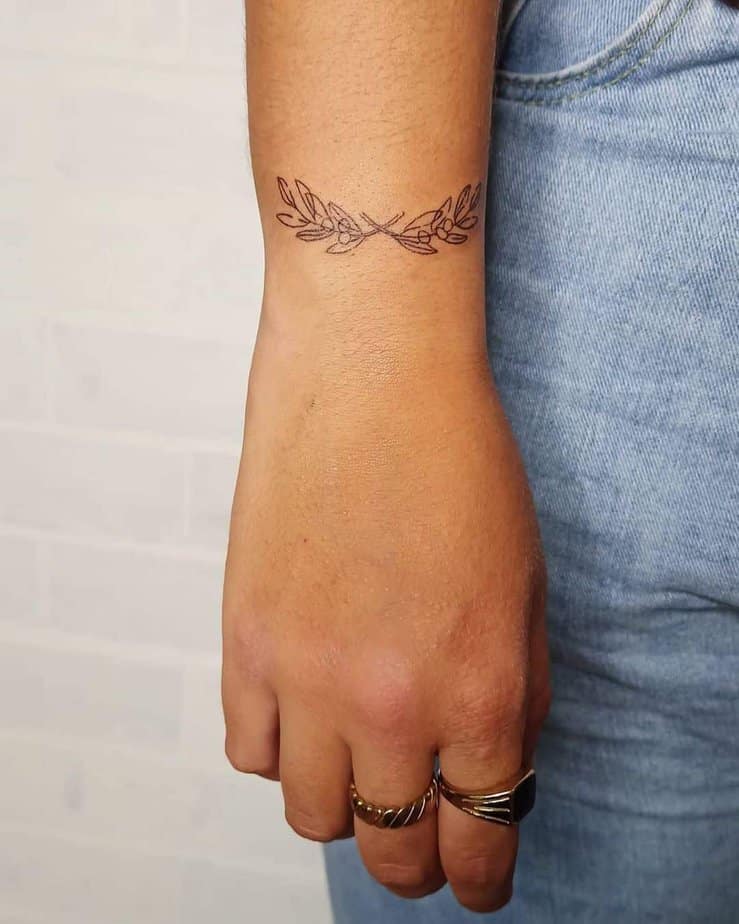 A tattoo of an olive branch on the wrist