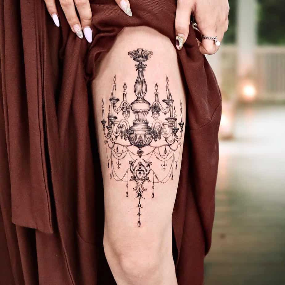 12. Regal chandelier thigh tattoo with detailed chains 1