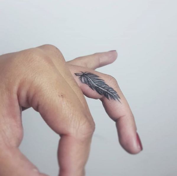 14. Bold black feather on the side of the finger