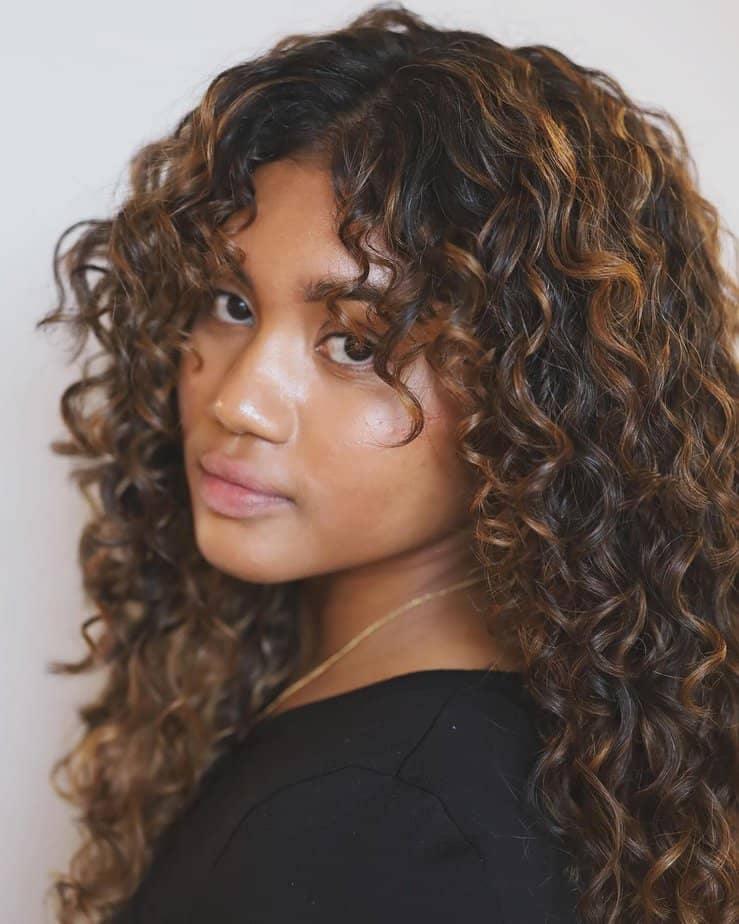 22. Warm caramel balayage on textured curls