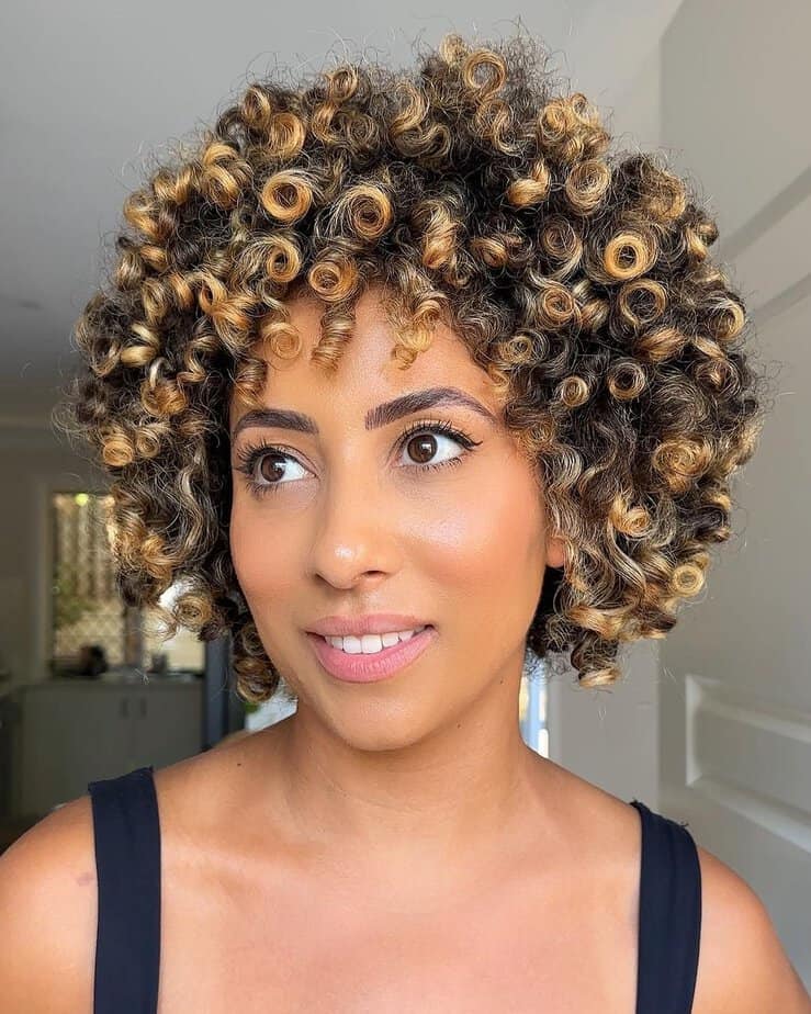 24. Short curls with golden blonde highlights