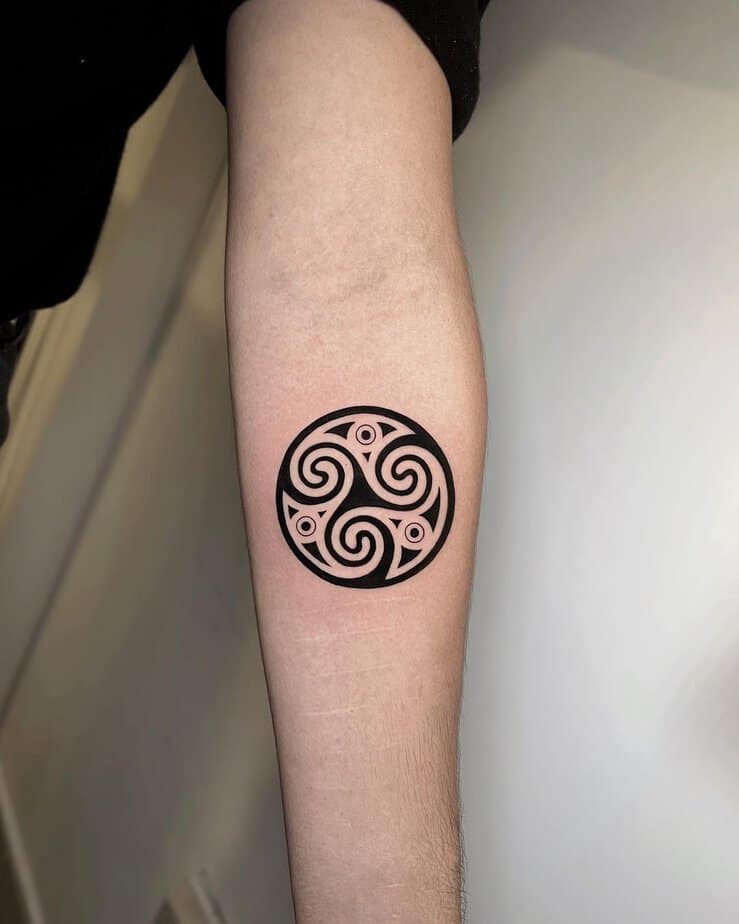 Black triskelion tattoo