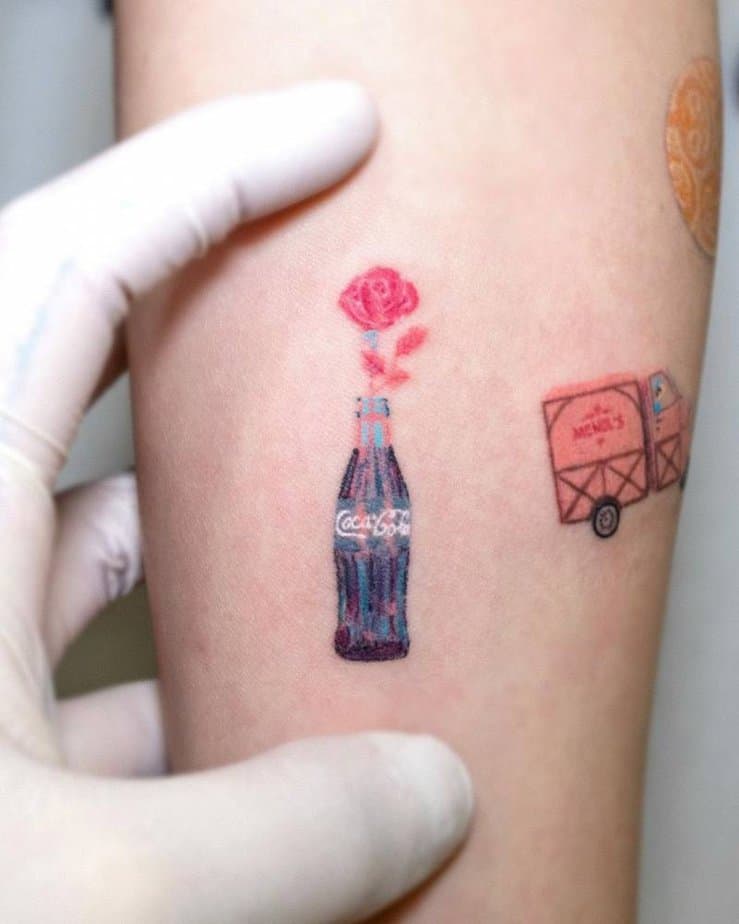 10. A pink rose in a Coca Cola bottle tattoo