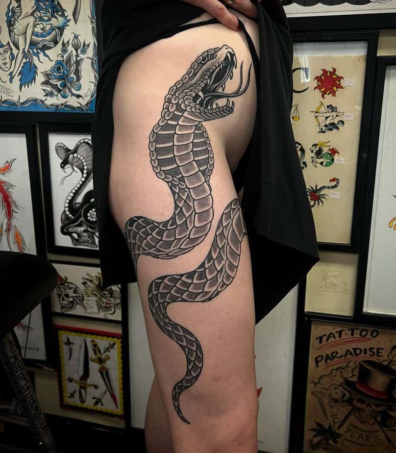 14. Giant black mamba on the thigh tattoo