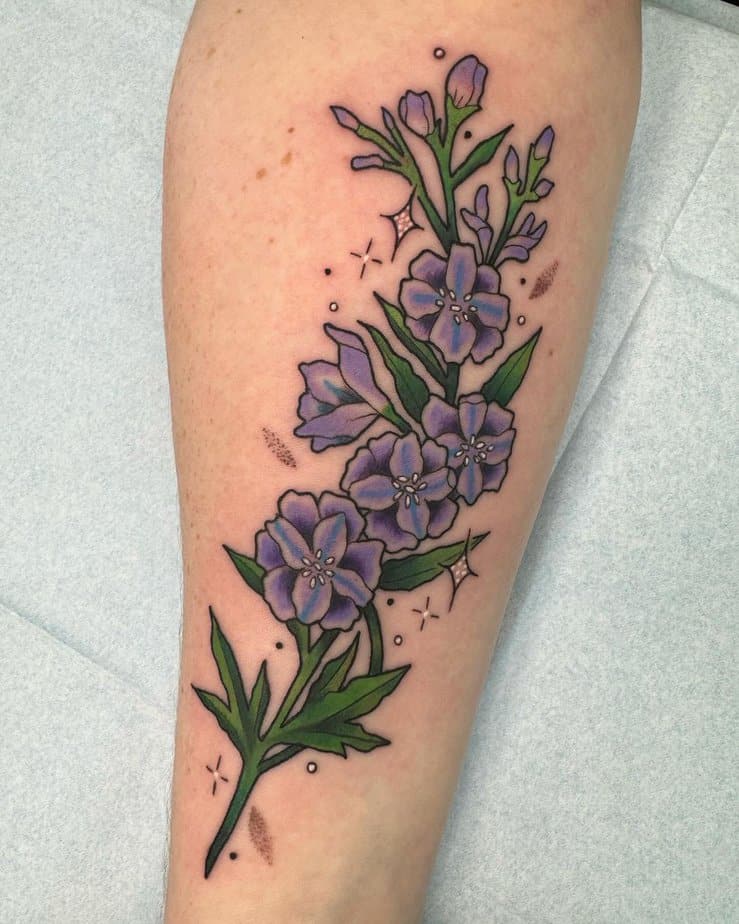 16. Bold purple larkspur tattoo with sparkle details