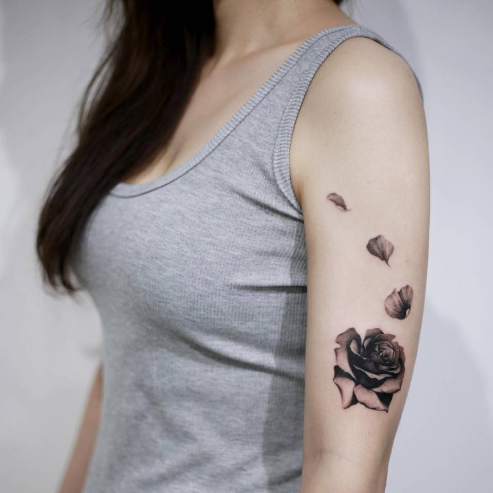 18. Black rose with falling petals on the arm