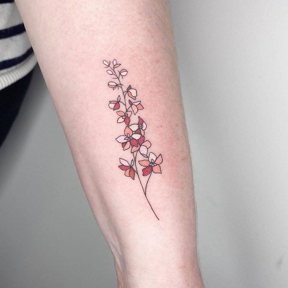 18. Soft pink larkspur tattoo on the forearm