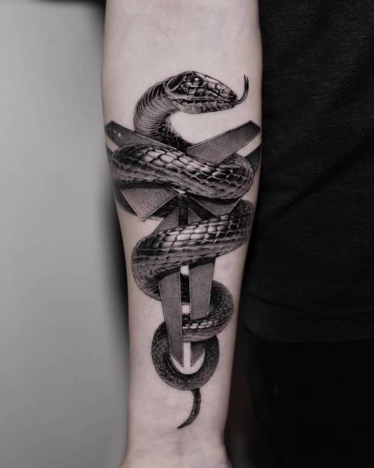 2. Black mamba wrapped around Kobe Bryants logo tattoo