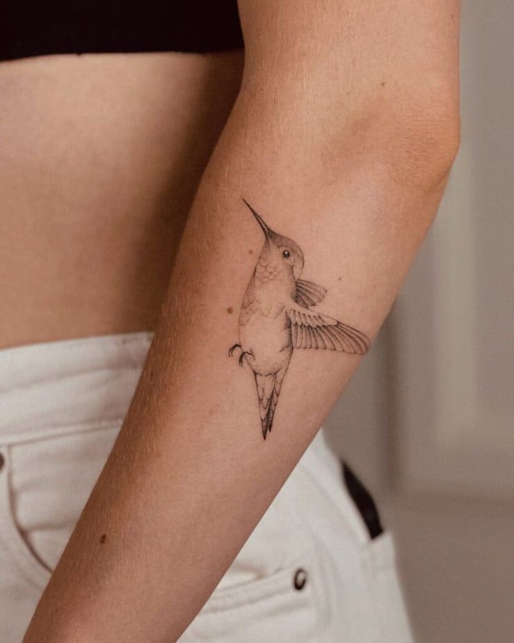 A hummingbird tattoo on the forearm