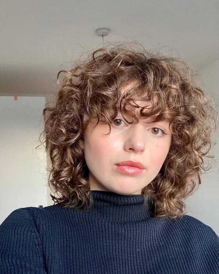 32. Soft curly bob with bangs