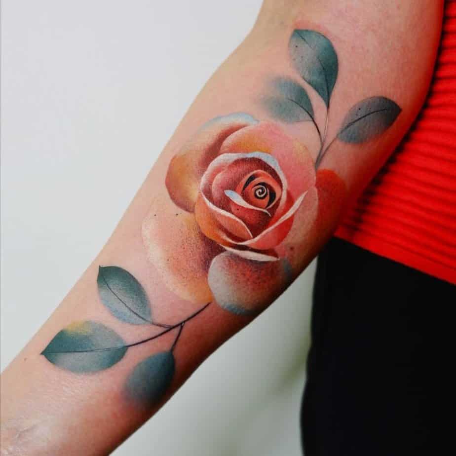 6. A realistic pink rose tattoo on the forearm