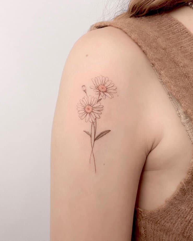 Delicate daisy tattoo on the shoulder